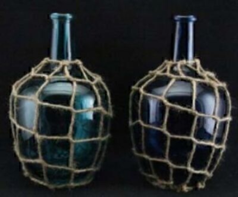 Choice of 2 blue glass bottle vases in twine net by Gisela Graham. These Bottle vases are decorative in their own right and would make a great ornament when not in use. They would compliment a beach or sea themed room or bathroom. Aqua or blue colour -